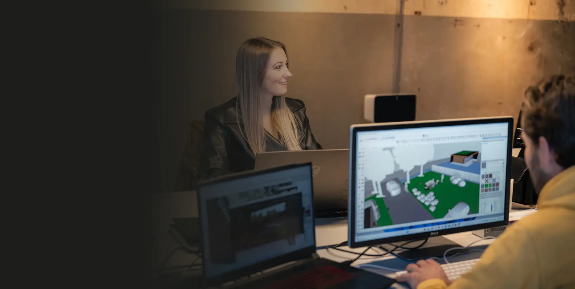 Een ontwerper van Distinkt werkt aan een 3D-model van een interieur op twee schermen