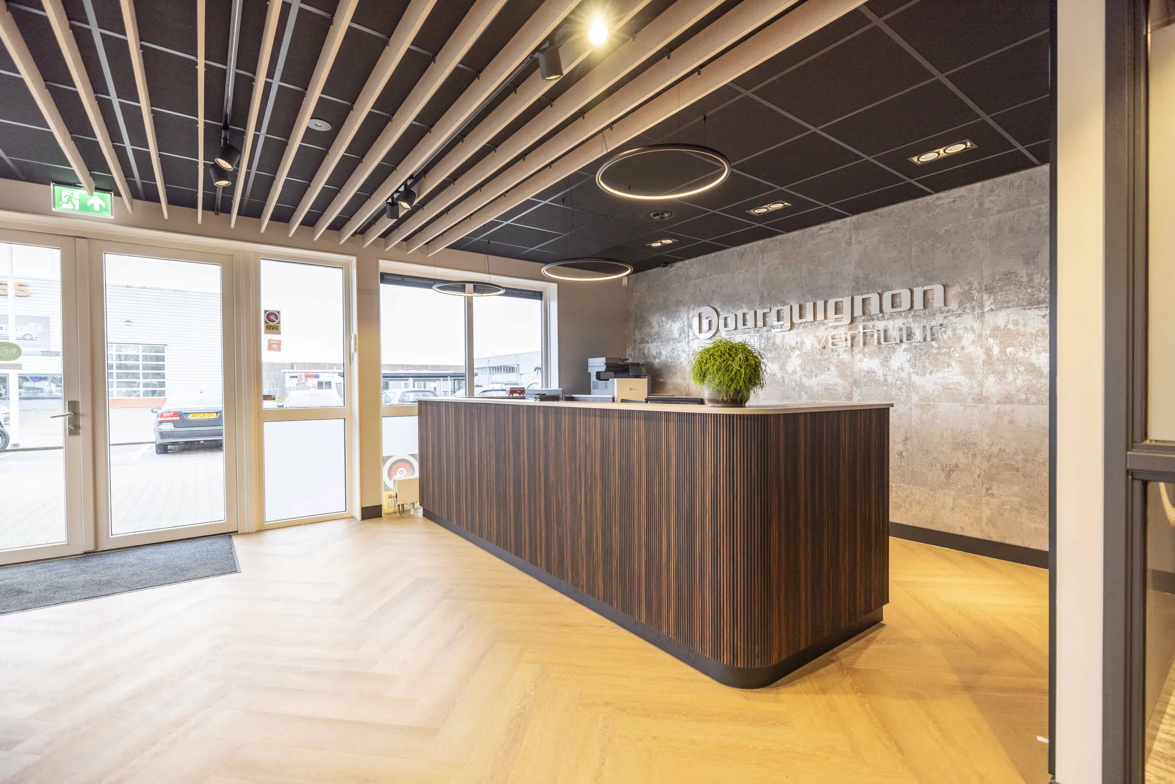 De nieuwe receptie met houten balie, visgraatvloer en ronde lichtcirkels