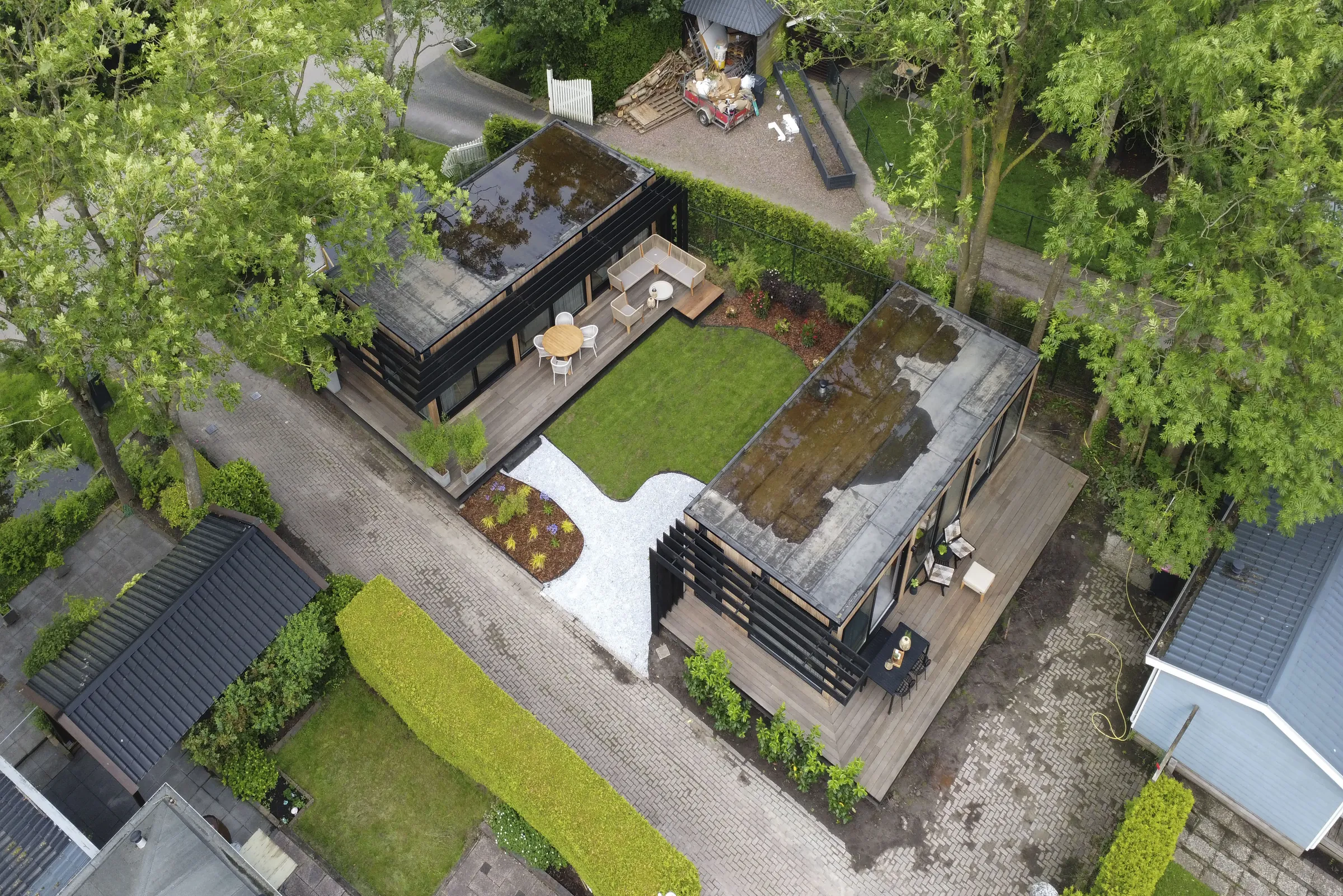 Luchtfoto van twee chalets met terras, gras en een groen dak