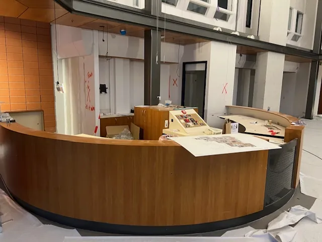 De gebogen balie tijdens de verbouwing, half bekleed met hout