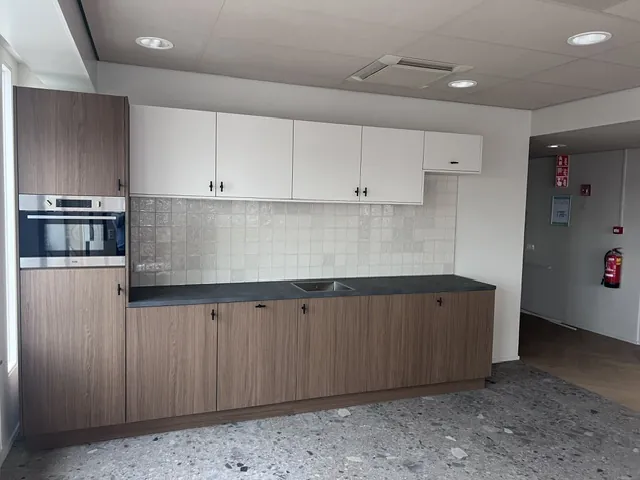 Een pantry met houten en witte kastjes op de vijfde verdieping
