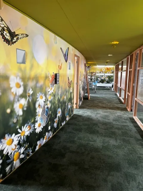 De gang tijdens de bouw: de wand met de bloemenwei zit er al op, aan het eind staat een ladder