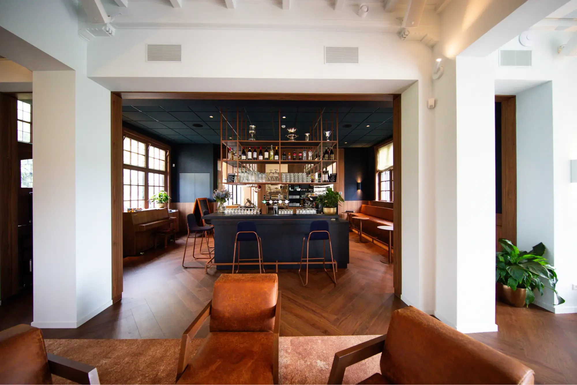 De bar van het clubhuis van de Noord Nederlandse Golf & Country Club, met leren fauteuils