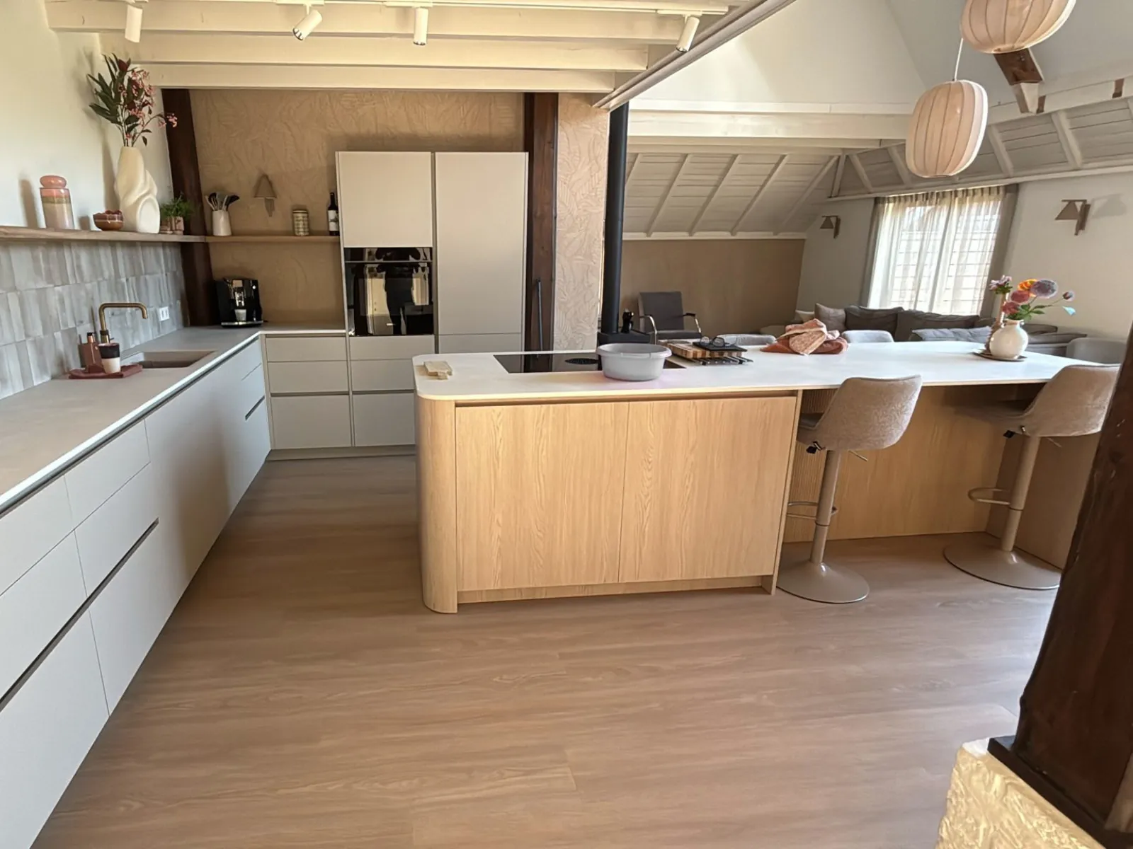 De opgeleverde keuken op maat, met een houten eiland en witte kasten