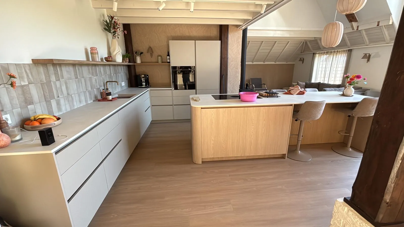 De opgeleverde keuken met de lange keukenwand en het eiland met houten front