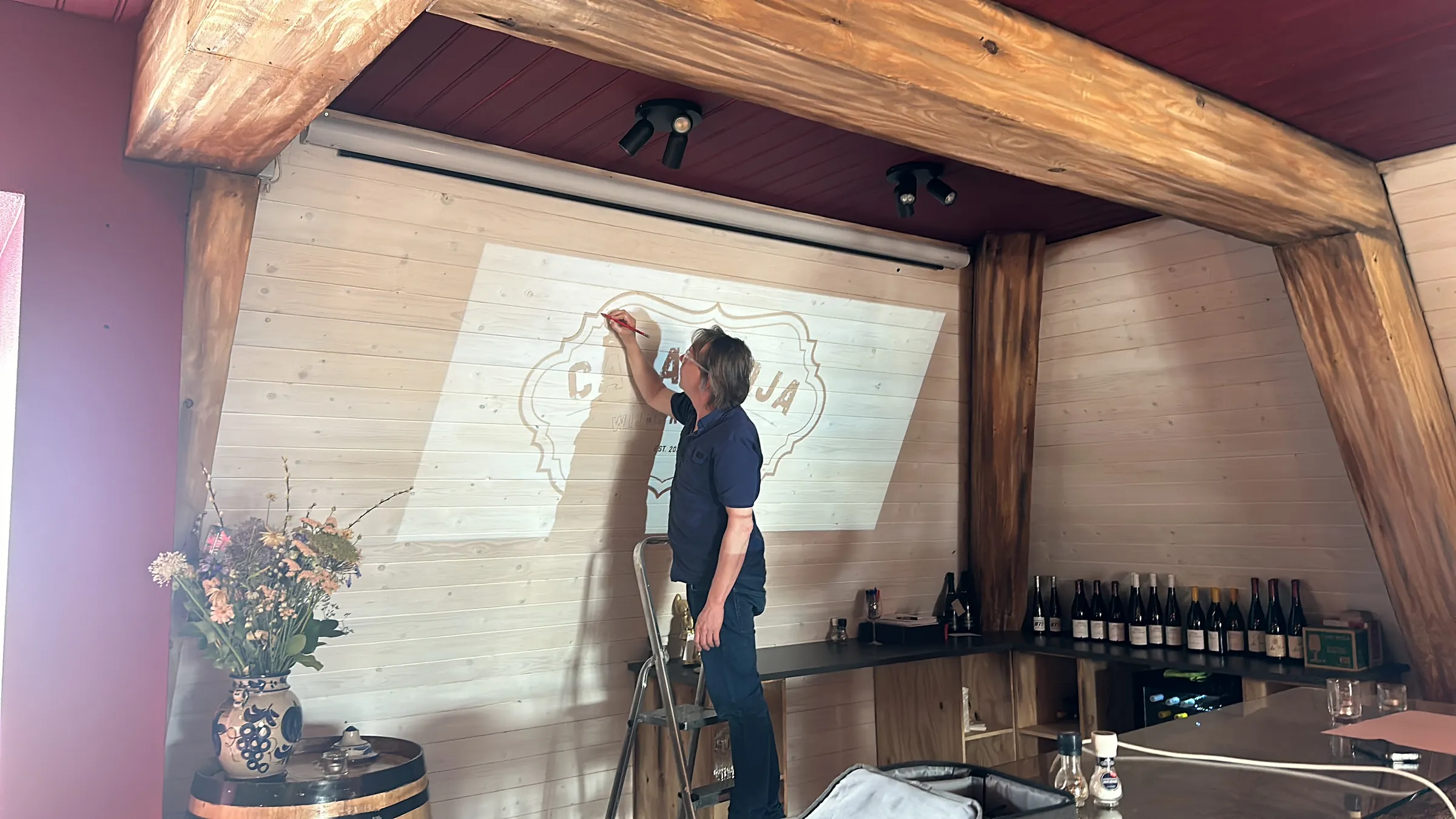 Het logo van Casa Rioja wordt met de hand op de houten wand geschilderd