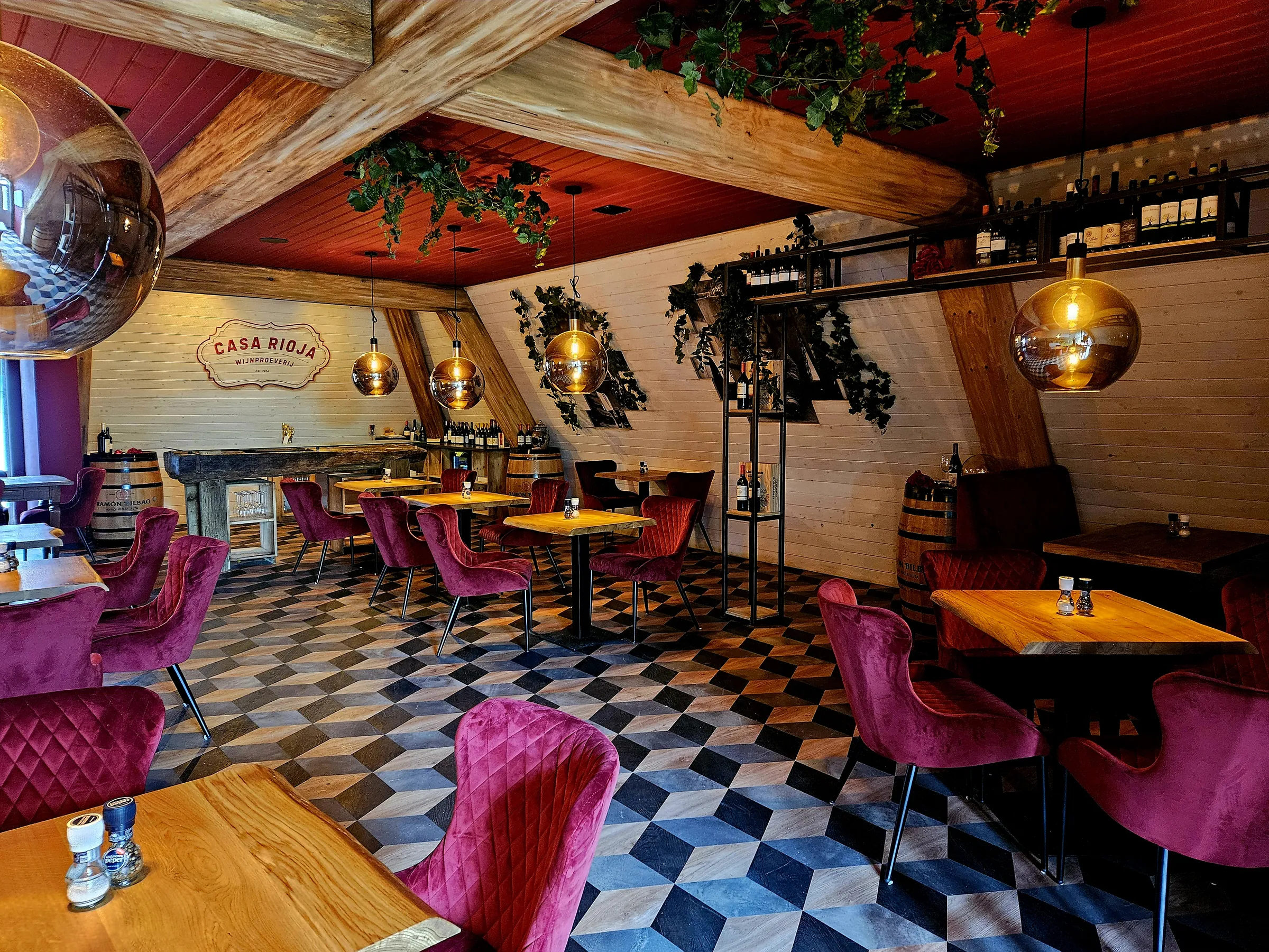De wijnzolder Casa Rioja bij De Jongens van Joure, met rode fluwelen stoelen en glazen bollampen