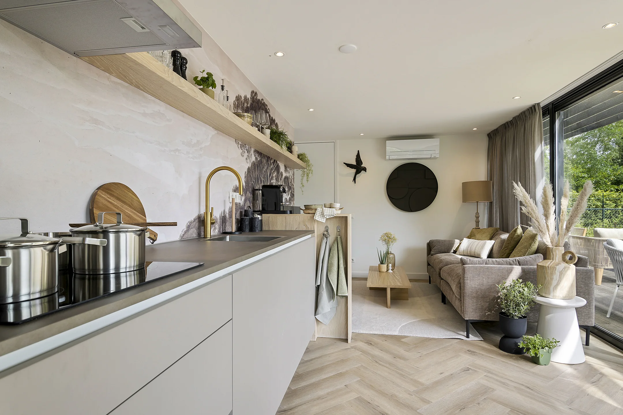 De keuken van een chalet in Grou met een lichte kookwand en uitzicht op de tuin